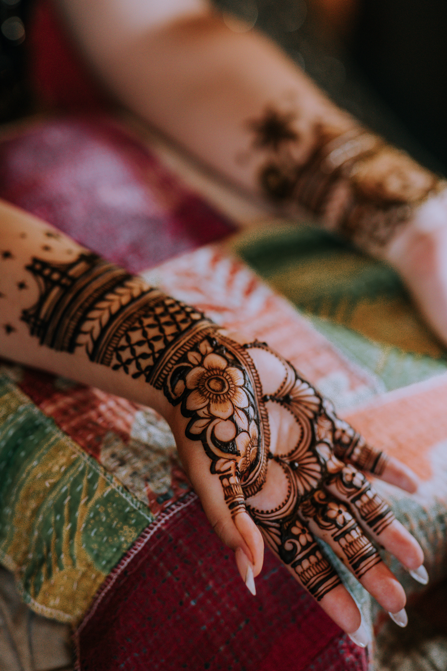 A lady showing intricate henna on her arms